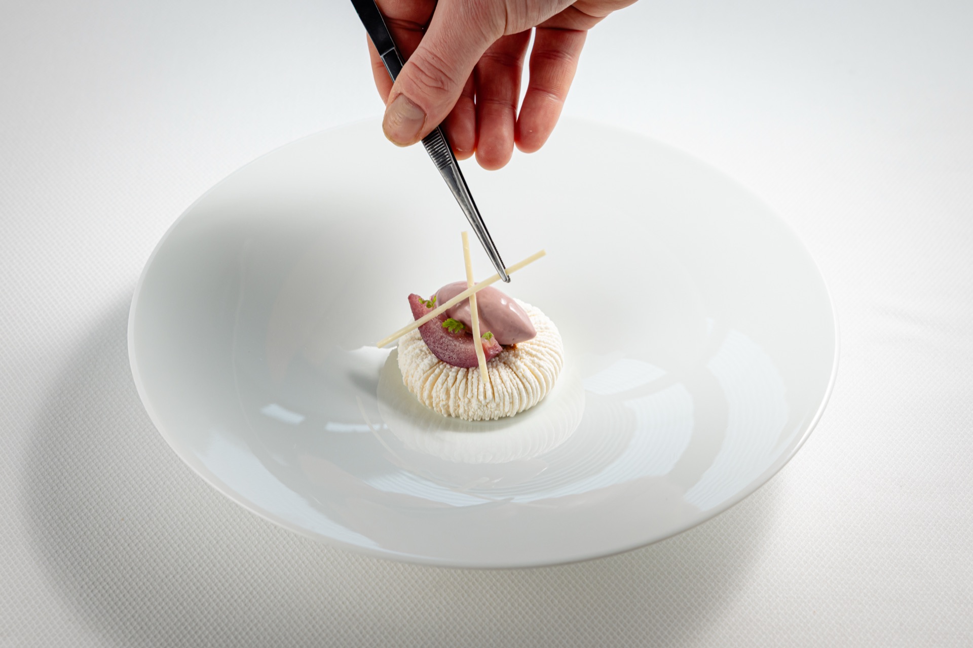 Dessert wordt zorgvuldig afgewerkt met een pincet
